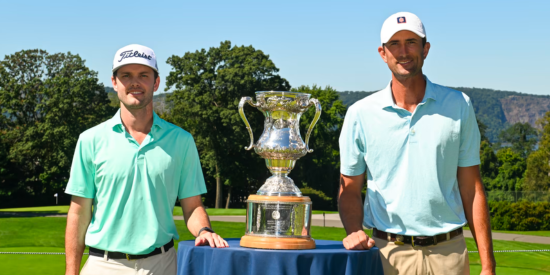 Stewart Hagestad and Evan Beck standing beside the Robert T. Jones Memorial Trophy