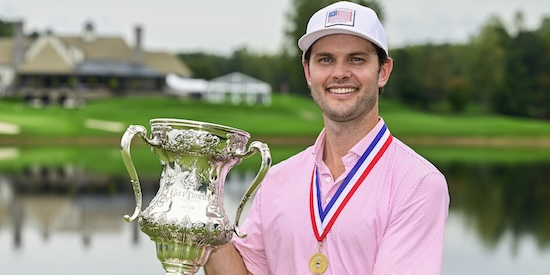 Evan Beck holding the Robert T. Jones Memorial Trophy and wearing a champion's medal